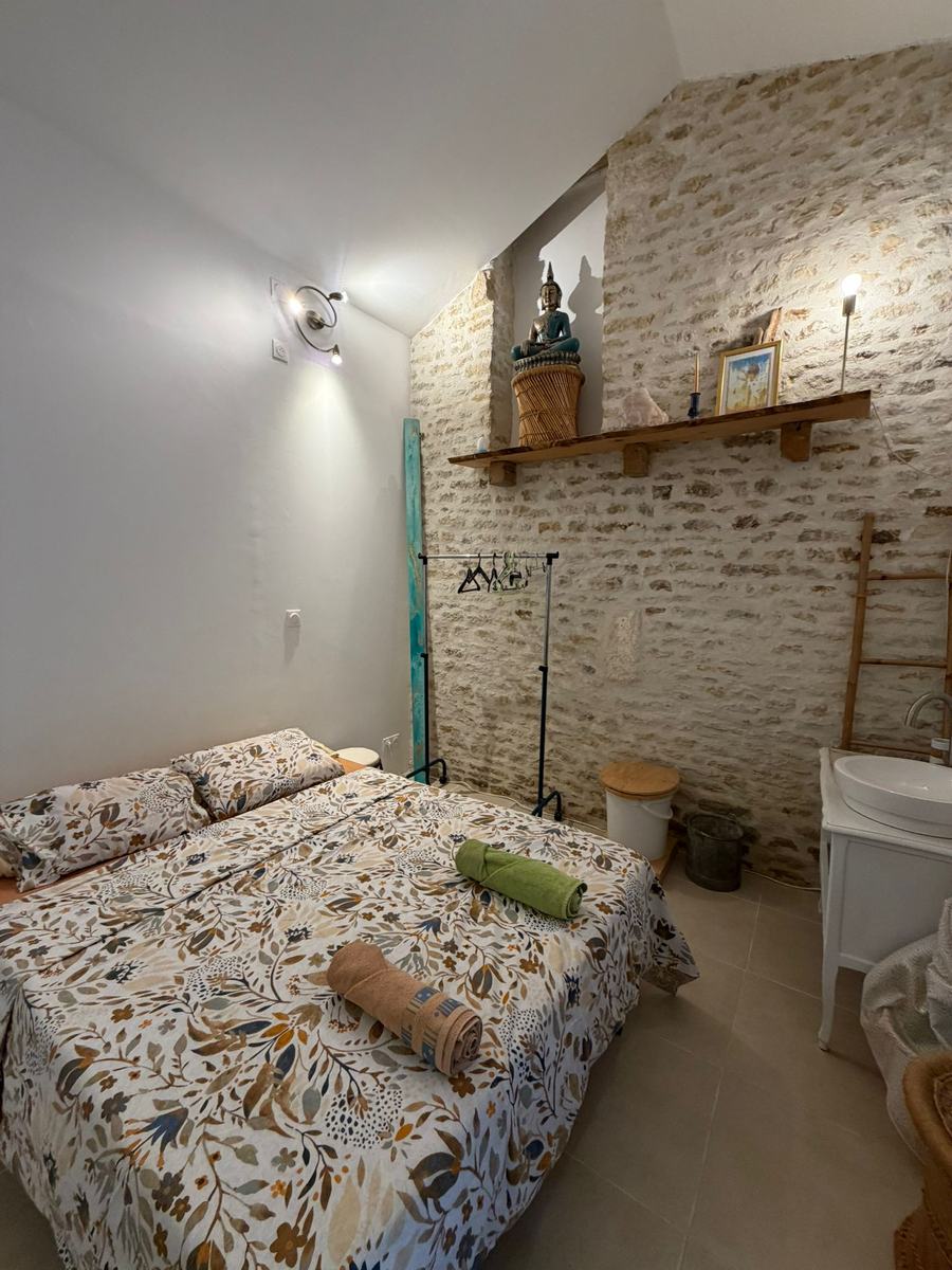 Le mur en pierre de 1681 et son étagère de bois, dans le Studio Zen à Liez